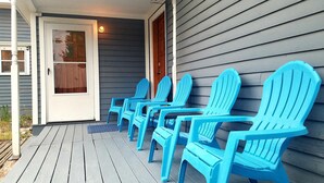 A porch with blue Adirondack chairs and a door. - Gowdy Apartment. Fenced yard pet friendly , modern, clean. Gowdy Properties (Lake City)