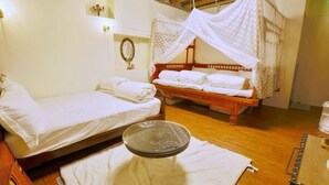 A room with two beds, a hanging chair, and a small table with a tray. - Moon House Tainan (Tainan)