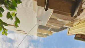 A traditional building with a green window frame, a corrugated metal roof, and two red lanterns hanging below the windows. - Moon House Tainan (Tainan)