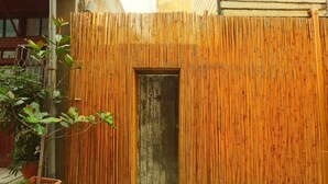 A bamboo fence with a small door in the center. - Moon House Tainan (Tainan)