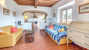 A cozy living room with a sofa, a wooden chest of drawers, and a television. - Lovely home in Sassetta with swimming pool (Sassetta)