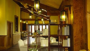 A cozy room with wooden beams, a wooden bookshelf, and hanging lanterns. - Songtsam Linka Lijiang (Lijiang)