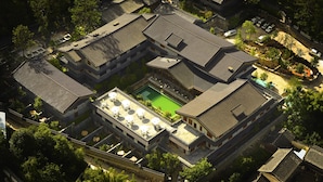 An aerial view of a traditional courtyard with a central pool, surrounded by multi-story buildings with tiled roofs. - Songtsam Linka Lijiang (Lijiang)