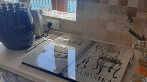 Une cuisine avec vue sur la mer, une machine à café et un crédence décorative.