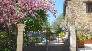 A stone building with a sign indicating 'Le Jardin d'Eden' and 'Gîtes de Charme'. - Gite 8p, 3*, air-conditioned heated pool, Spa, playground, wifi, ok dog cat (MONTIGNAC-LASCAUX)