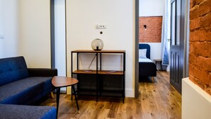 A modern living room with a sofa, a small table, and a console table with a lamp. - MB2- Gwarna 11 (Wroclaw)