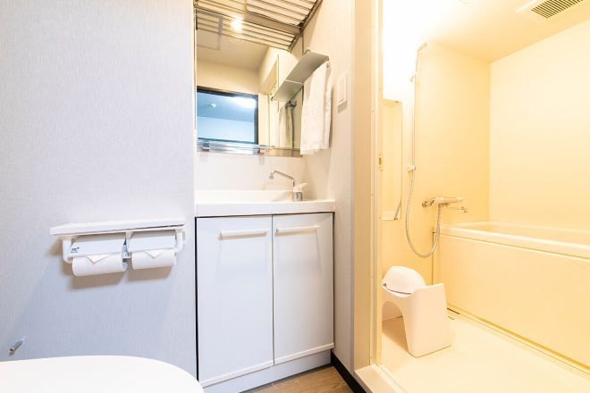 Un baño con inodoro, lavamanos y ducha.
