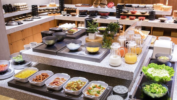 A buffet with various food items and serving utensils.