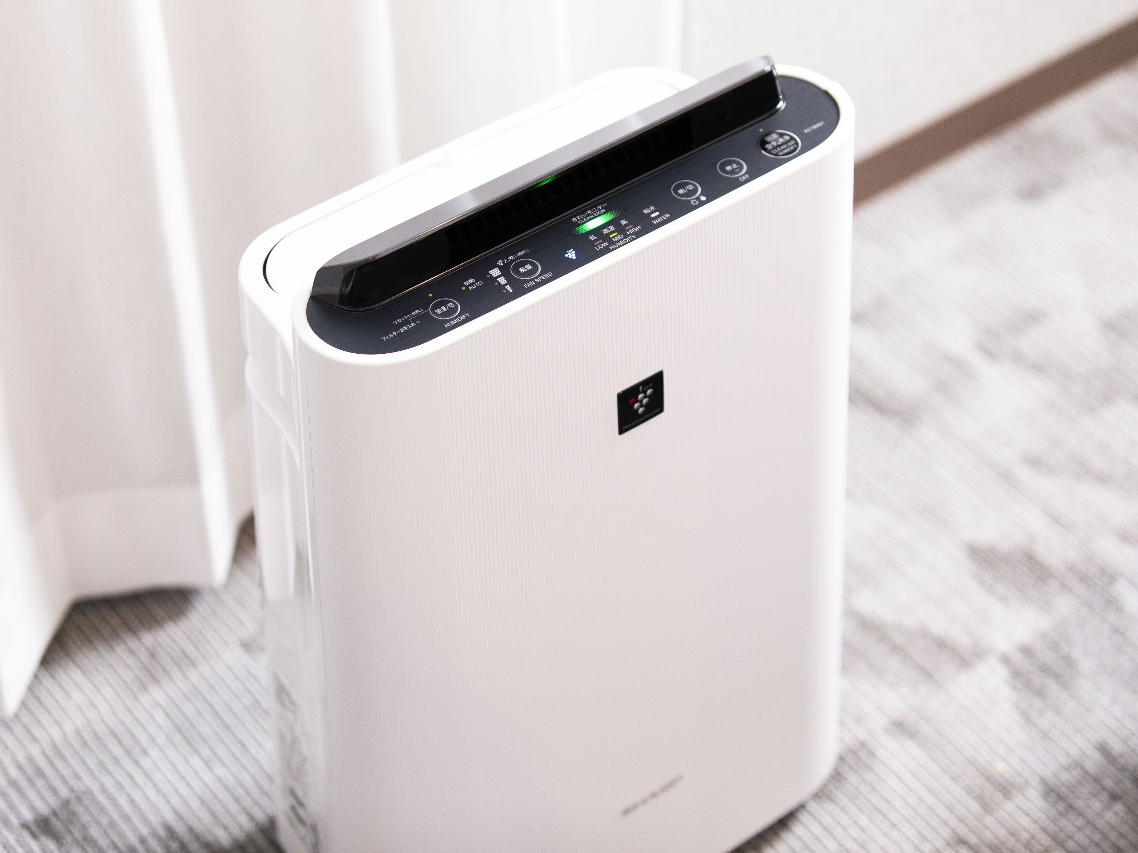 A white portable air purifier with a control panel displaying various settings.
