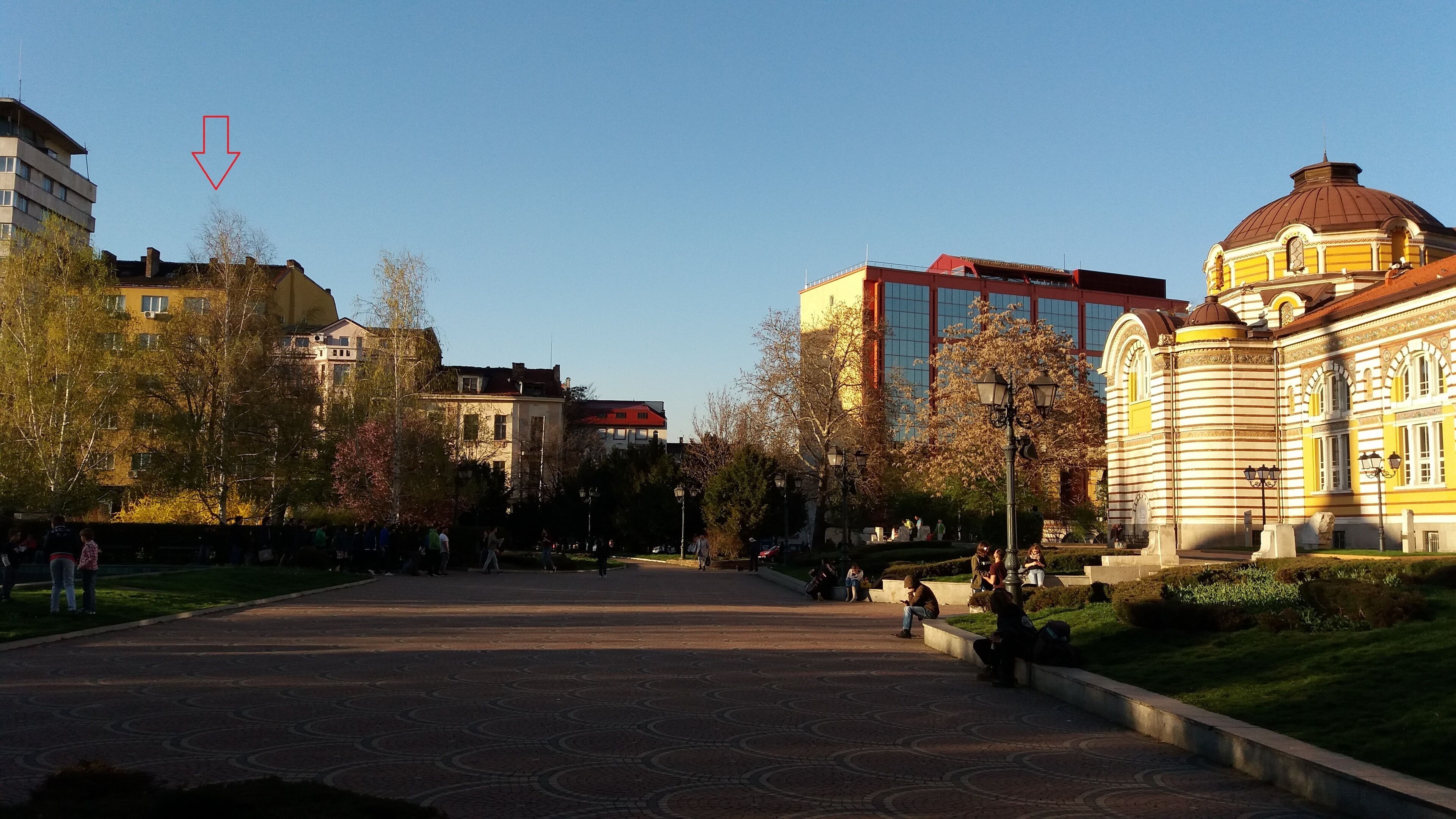 Una amplia plaza pública con pavimento estampado, rodeada de edificios históricos de arquitectura clásica.