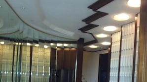 A spacious lobby with a polished wooden floor, a staircase, and a large mirror reflecting the room. - JUAN LES PINS STUDIO SEA VIEW (Juan Les Pins)