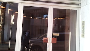 A hotel entrance with a glass door, a sign reading "LE CLIPPER A", and a parking sign indicating a garage. - JUAN LES PINS STUDIO SEA VIEW (Juan Les Pins)