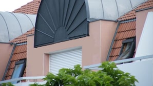 Un bâtiment doté d’une structure de toit incurvée et métallique, ainsi que d’une fenêtre blanche.