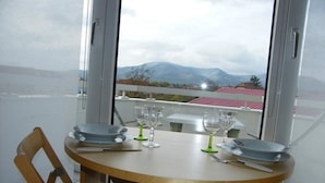 Une table ronde en bois, mise pour le repas, avec des assiettes, des verres et des couverts.