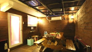 A wooden interior with a bench, a table with items, and a window with light. - Hotel Yaja Uijeongbu Station (Uijeongbu)