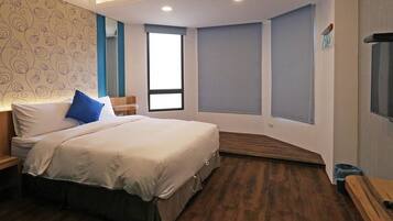 Un dormitorio con cama, mesita de noche, ventana y un banco empotrado.