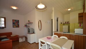 A compact living space with a kitchenette, a dining area, and a sofa.