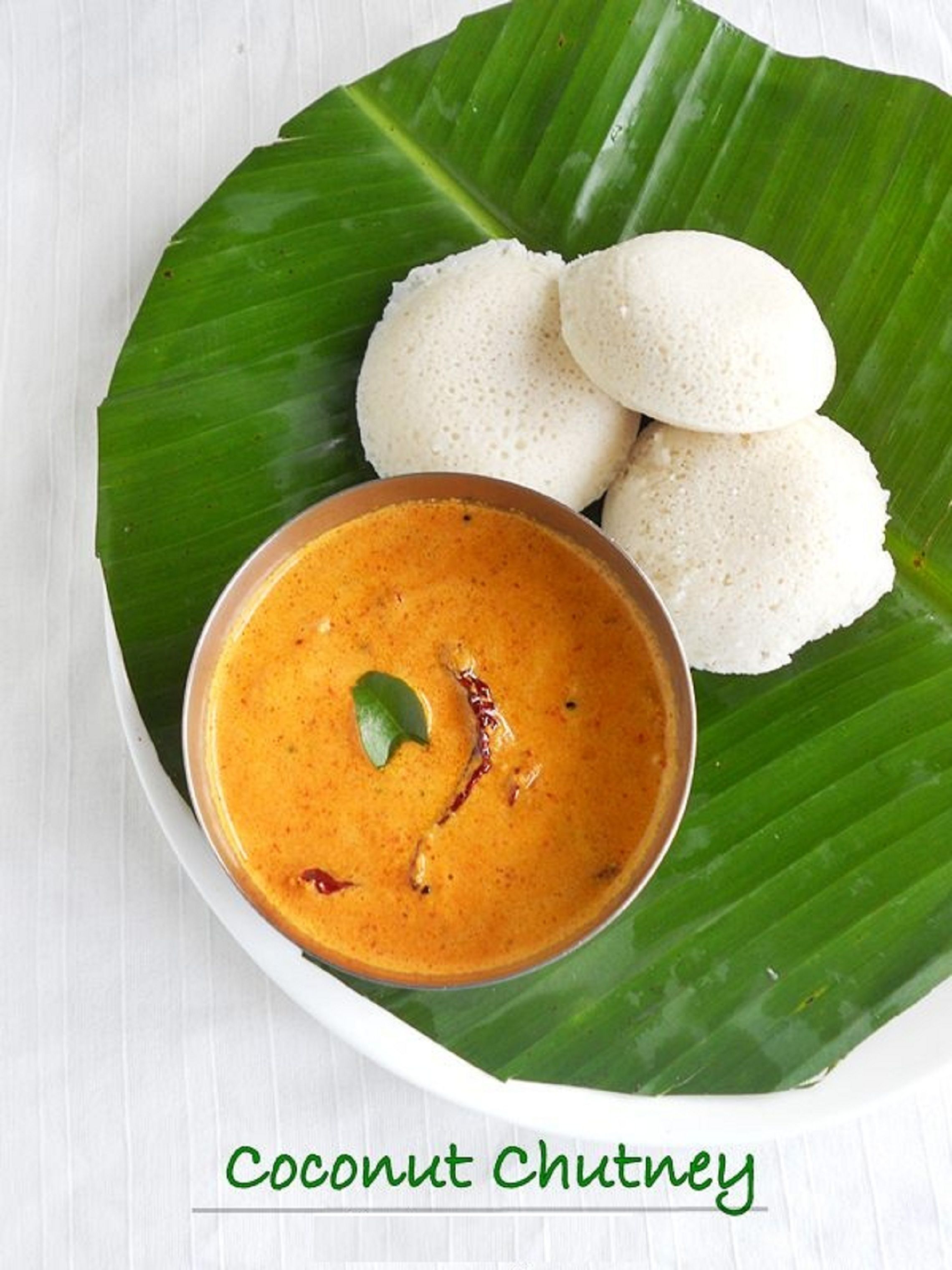 Un piatto di chutney di cocco e due idli su una foglia di banano.