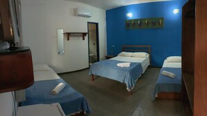 A hotel room with three beds, a mirror, a wall-mounted artwork, and a small table. - Pousada Manacá (Paraty)