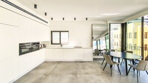 Een moderne keuken met witte kastjes, een zwarte oven en een raam boven de spoelbak.