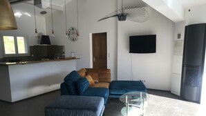 A modern living room with a sofa, ottoman, and a glass coffee table. - villa near Ajaccio with swimming pool in the heart of nature (Ocana)