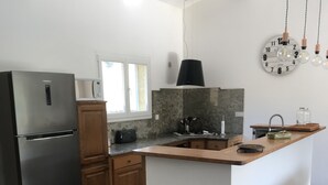 A modern kitchen with a central island, stainless steel refrigerator, wooden cabinets, and a microwave. - villa near Ajaccio with swimming pool in the heart of nature (Ocana)