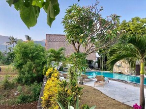 Una piscina al aire libre, sillones reclinables de piscina