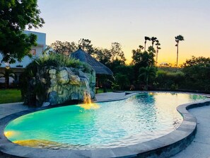 Una piscina al aire libre, sillones reclinables de piscina