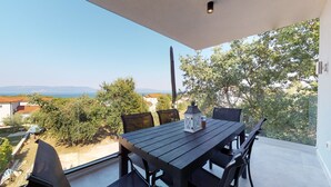 A balcony with a table and chairs, overlooking a scenic view of trees and a distant landscape. - Istrian Pearl (Rasa)