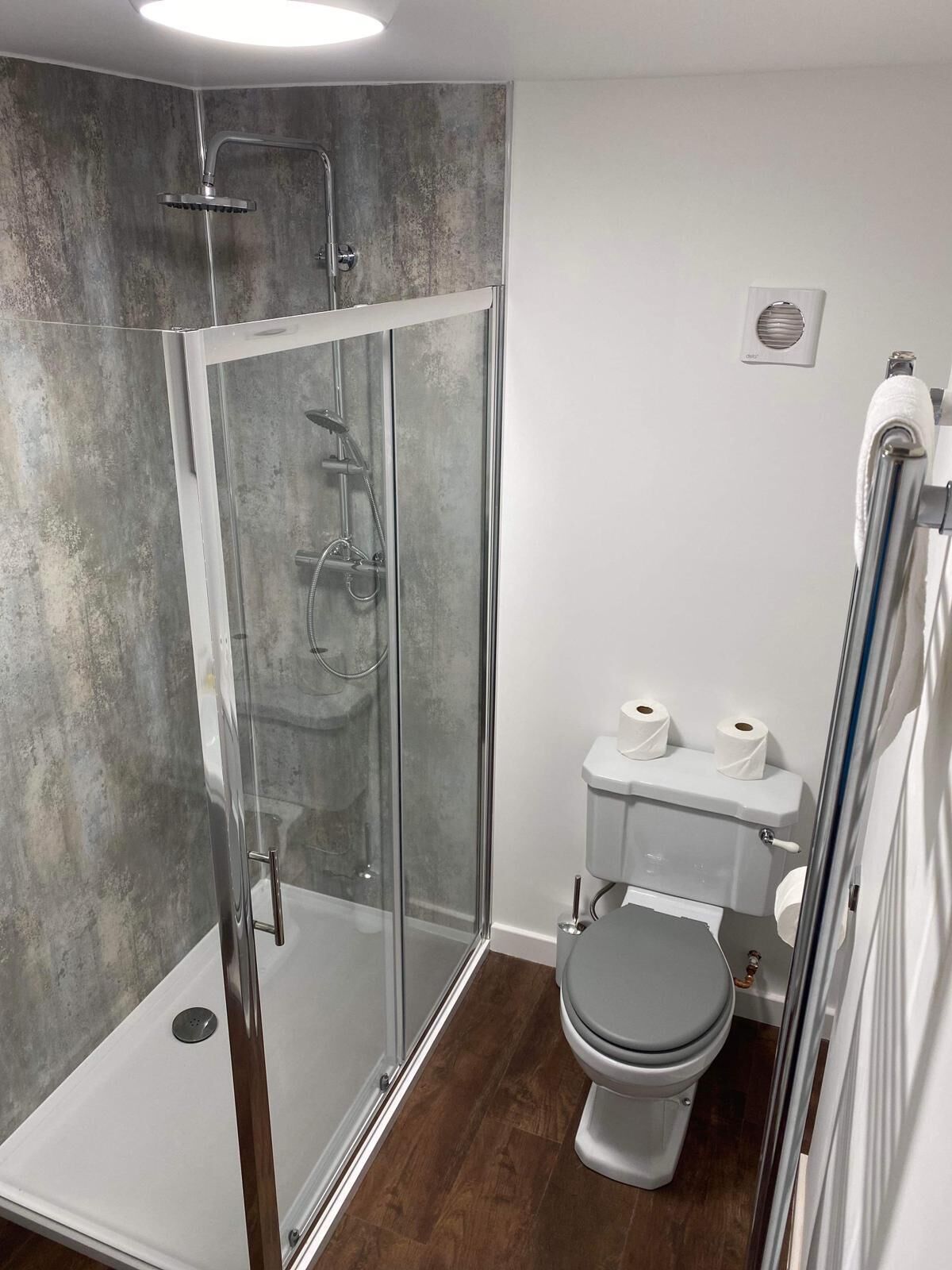 Une salle de bain moderne avec une douche à parois de verre, des toilettes et un lavabo.