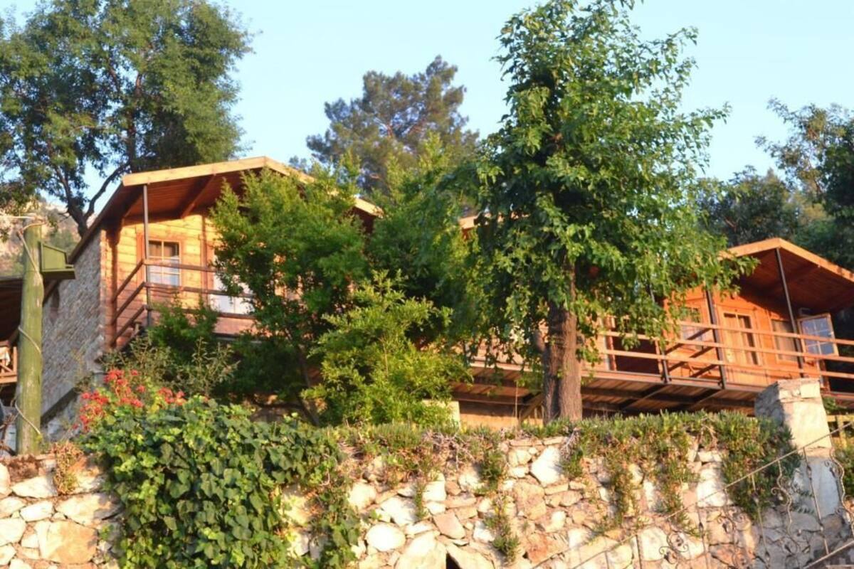 Un chalet rustique avec des fondations en pierre, des poutres en bois et un balcon.
