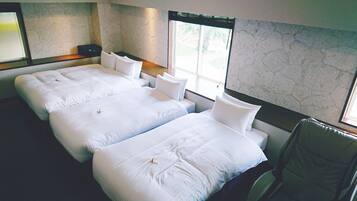 A hotel room with two beds, a chair, and a large window.
