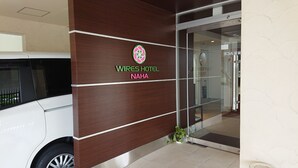 A hotel entrance with a wooden facade and a glass door. - Wires Hotel (Naha)