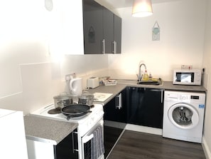 Departamento Confort, 1 cama Queen size y sofá cama, patio | Cocina privada | Refrigerador con congelador, microondas, horno y parrilla de estufa