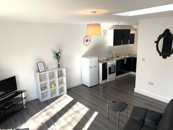 Departamento Confort, 1 cama Queen size y sofá cama, patio | Área de sala de estar | Televisión LCD de 38 pulgadas con canales premium y televisión
