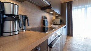 A modern kitchen with stainless steel appliances, wooden countertops, and a built-in oven. - A CASA Elegance (Laengenfeld)