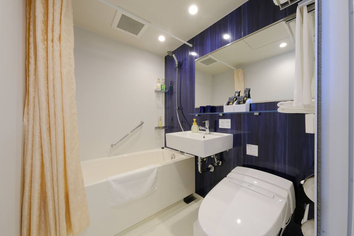 deluxe twin room | bathroom | free toiletries, slippers, bidet, towels