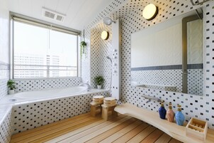 Un baño moderno con un ventanal grande, una bañera, un lavabo y un espejo.