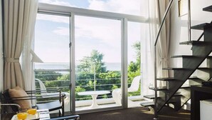 Une chambre moderne avec un balcon, un coin repas comprenant une table et des chaises, et un escalier.