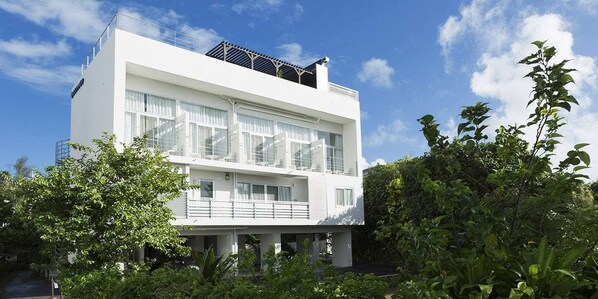 A modern two-story building with large windows and a balcony. - Wires Hotel Onna Clipper Okinawa Base (Onna)