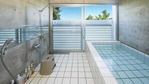 Une salle de bain moderne dotée d’une douche à parois de verre, d’une baignoire et de toilettes.