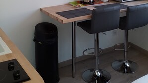 A hotel room with a bed, a desk with a chair, a television, a microwave, and a trash bin. - Lens Louvre 2 (Lens)