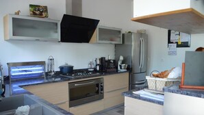 A modern kitchen with a built-in oven, stainless steel refrigerator, and a microwave. - Lens Louvre 2 (Lens)