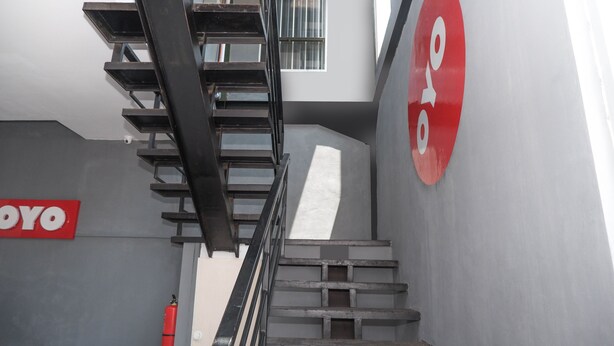 A staircase with a metal railing, a fire extinguisher, and a 'YOYO' sign on the wall. - OYO 682 Ceria Homestay Syariah (Semarang)
