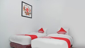 A room with two beds, each with a red and white bedspread and matching pillows. - OYO 682 Ceria Homestay Syariah (Semarang)