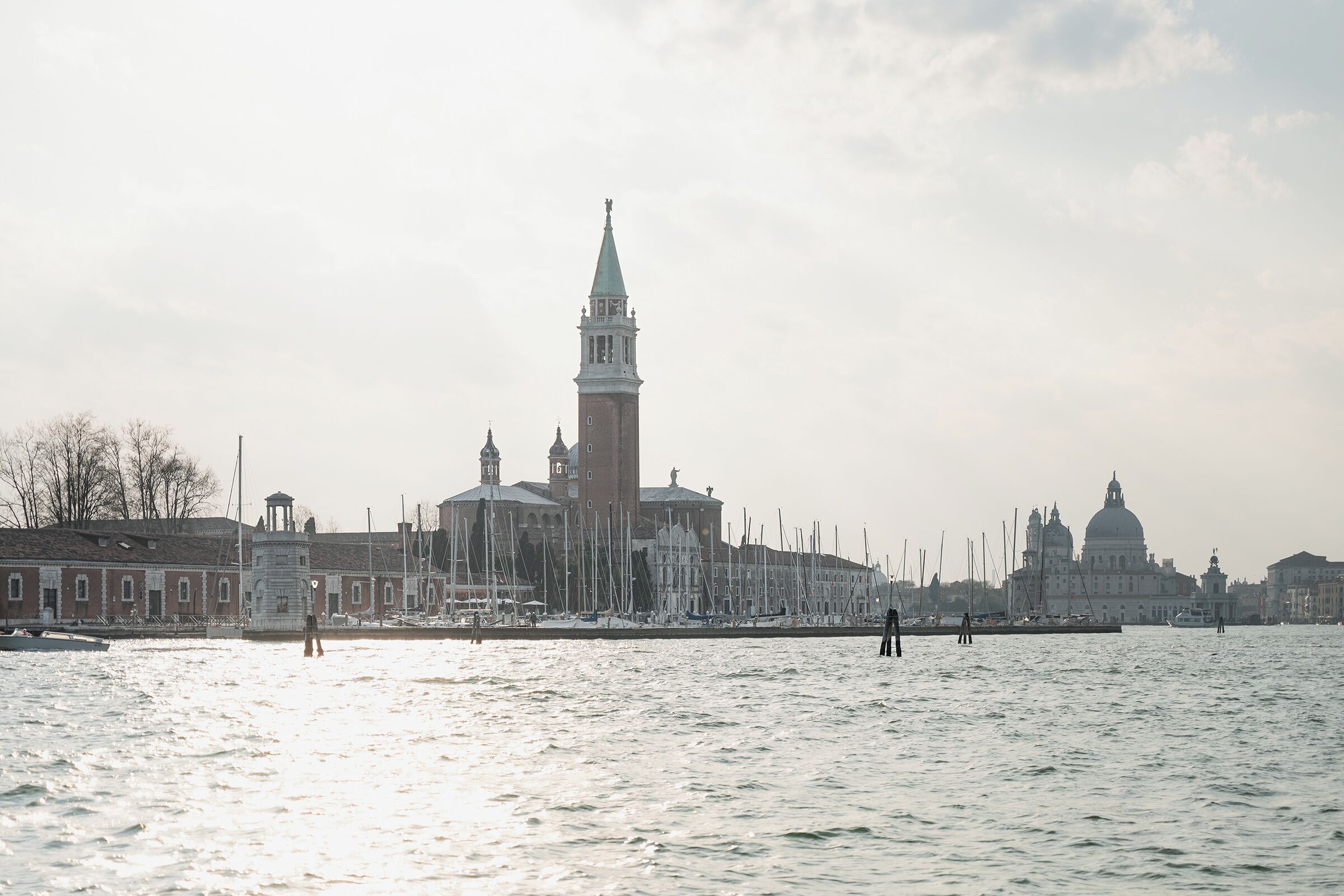 A waterfront view with historic buildings, including a prominent tower and domed structures.