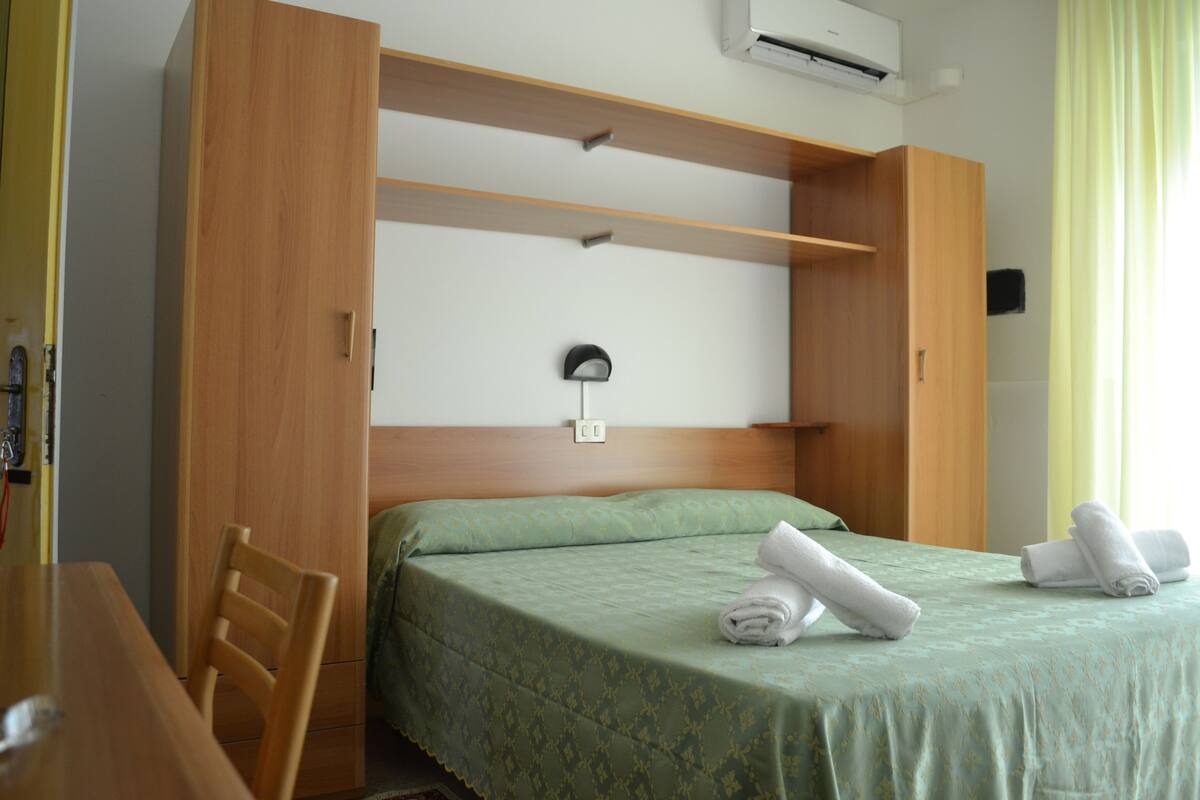 Una habitación de hotel con cama, escritorio y silla.