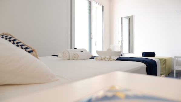 A hotel room with a bed, a bedside table, a chair, and a window. - Kalinifta Rooms Apartment (Porto Cesareo)