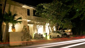 A modern building with a covered outdoor area, a parked vehicle, and a tree. - Anza d'Dimmel Jimbaran (Jimbaran)