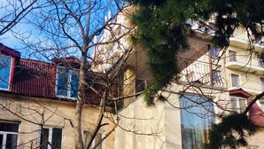 A building with a yellow facade, a red bicycle parked outside, and a sign that reads "Koleso". - Hostel Koleso (Odesa)